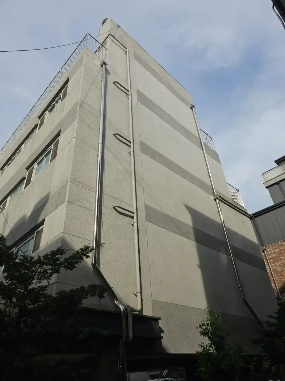 낡은 PVC 선홈통 교체 시공 후 — 외벽 모서리 따라 선홈통 마감