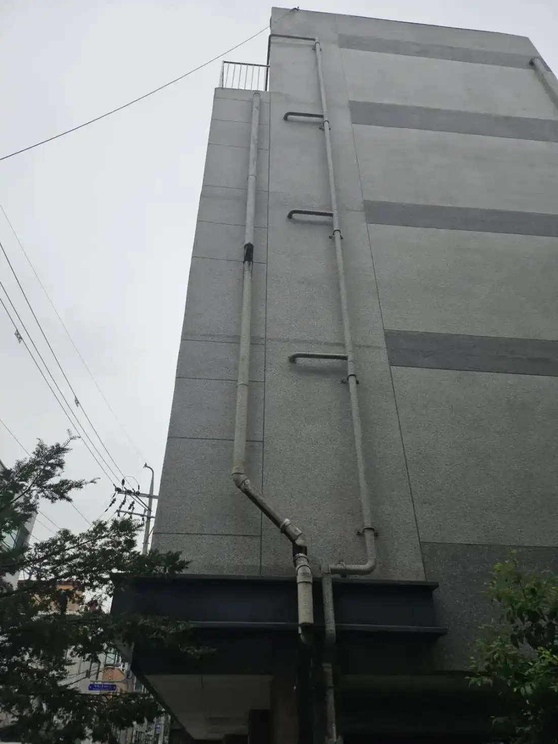 낡은 PVC 선홈통 교체 시공 전 — 교체 후 정돈된 외벽 라인
